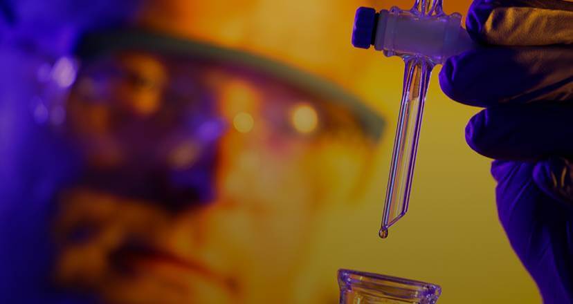 An up close image of a chemist using labratory equipment.