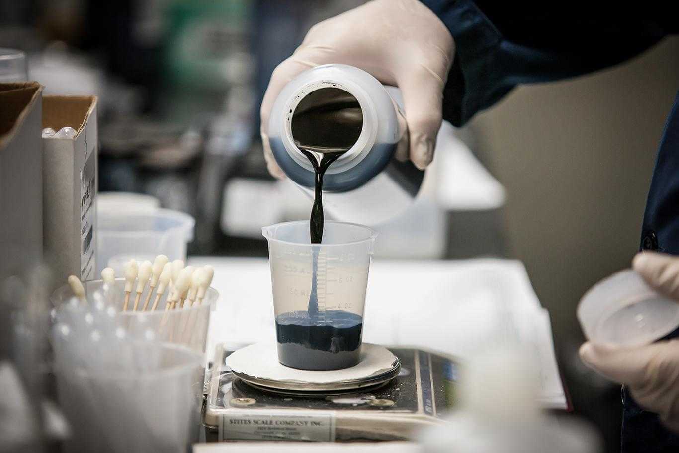 An up close image of a chemist using labratory equipment.