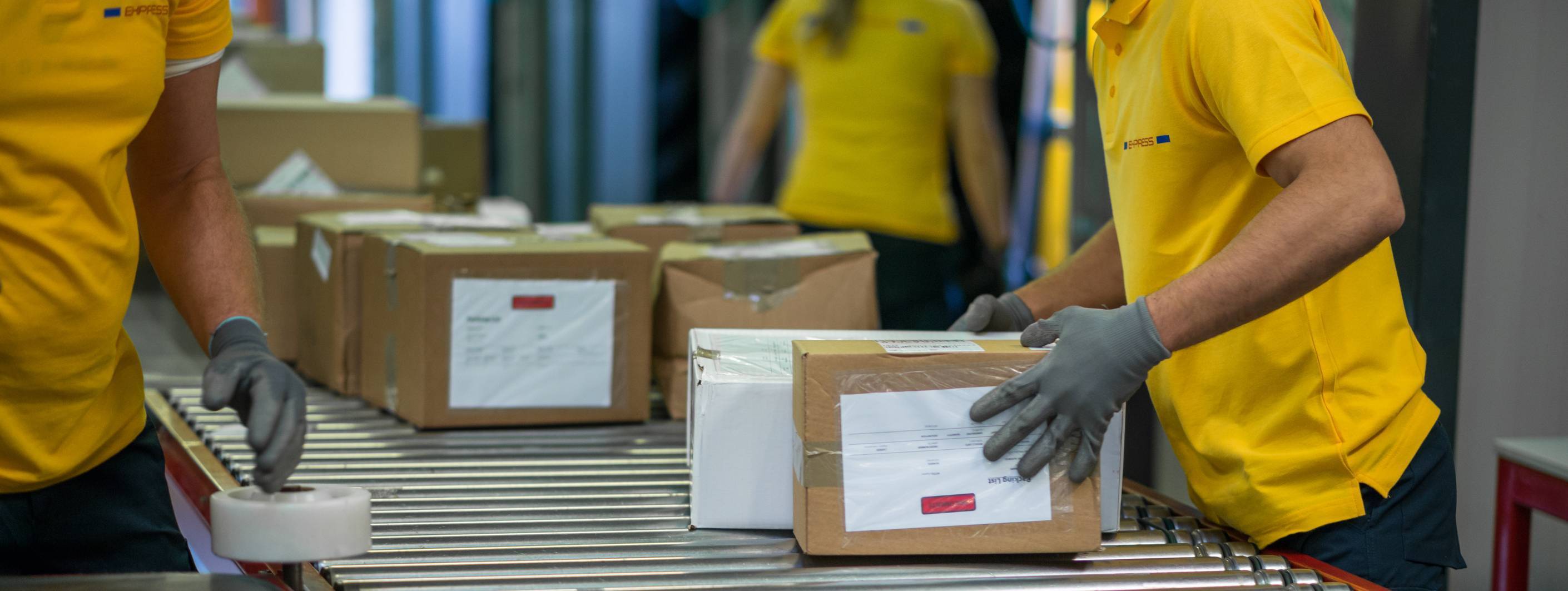 Workers handling cardboard boxes on an assembly line.