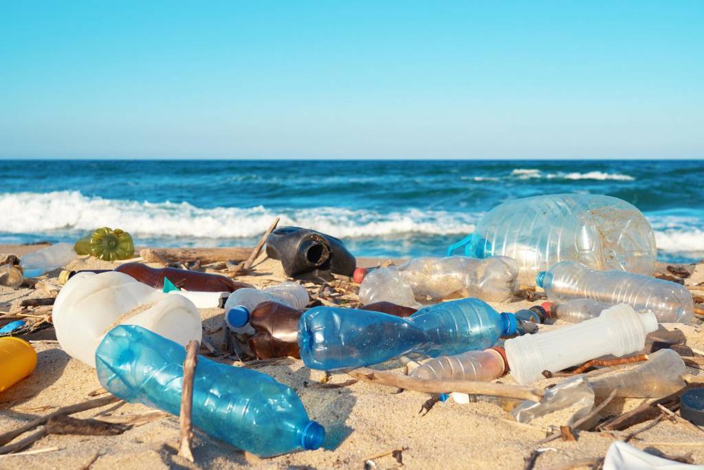 ocean waste plastic packaging on a beach leading movement to circular economy trend