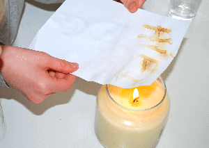 A candle heating a piece of paper.