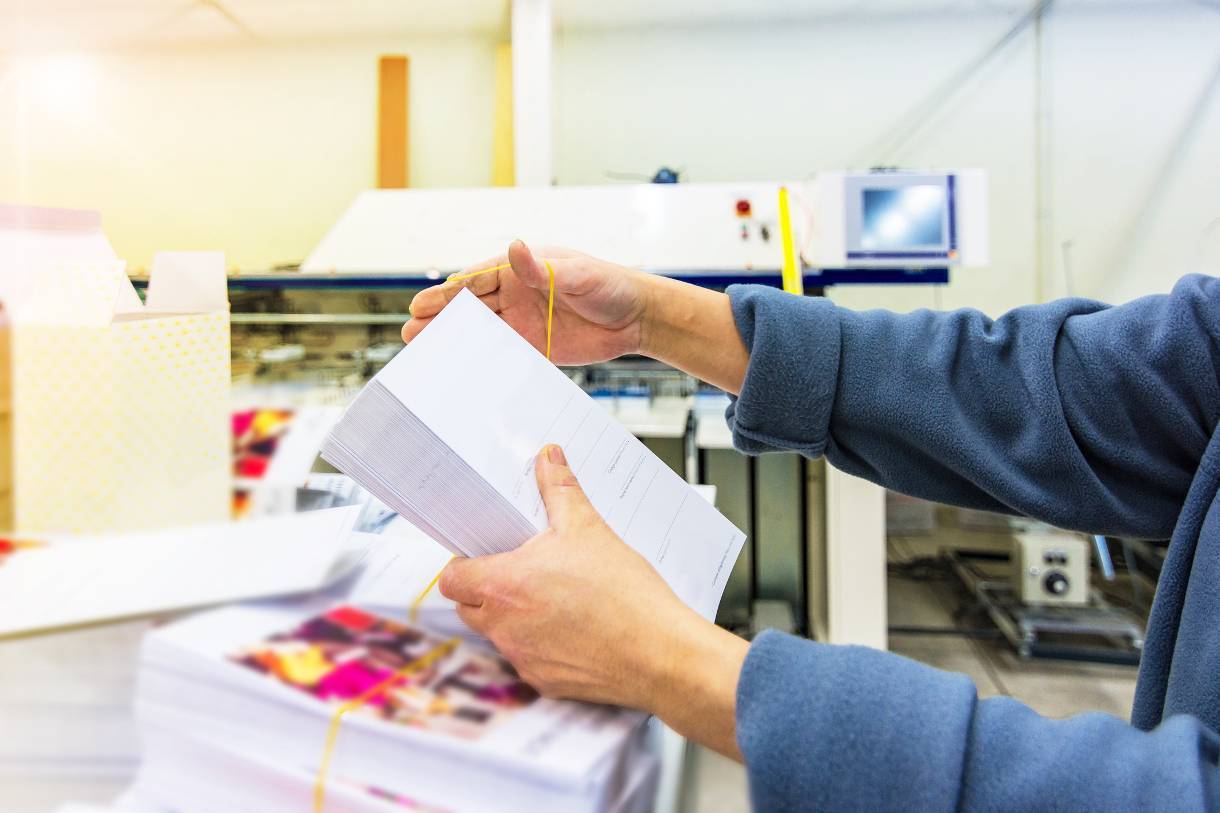 Worker preparing printed advertising for mailing