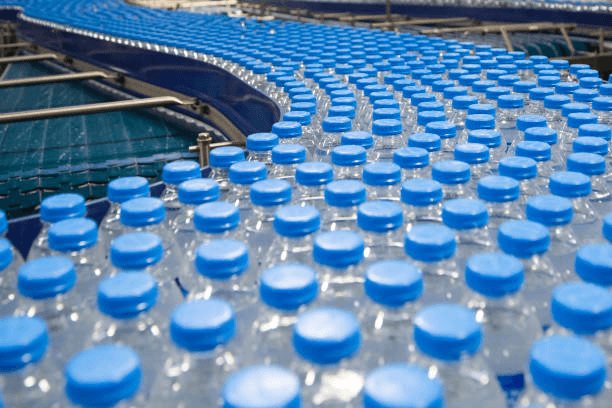 blue capped plastic bottles on a conveyor
